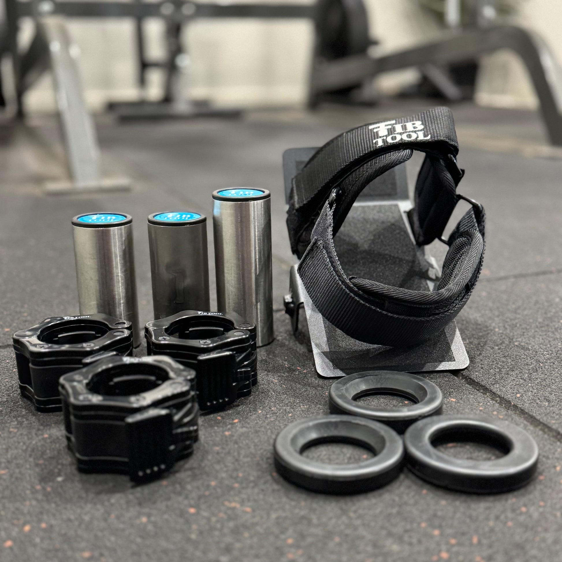 Set of gym equipment including weights and straps on a concrete surface.