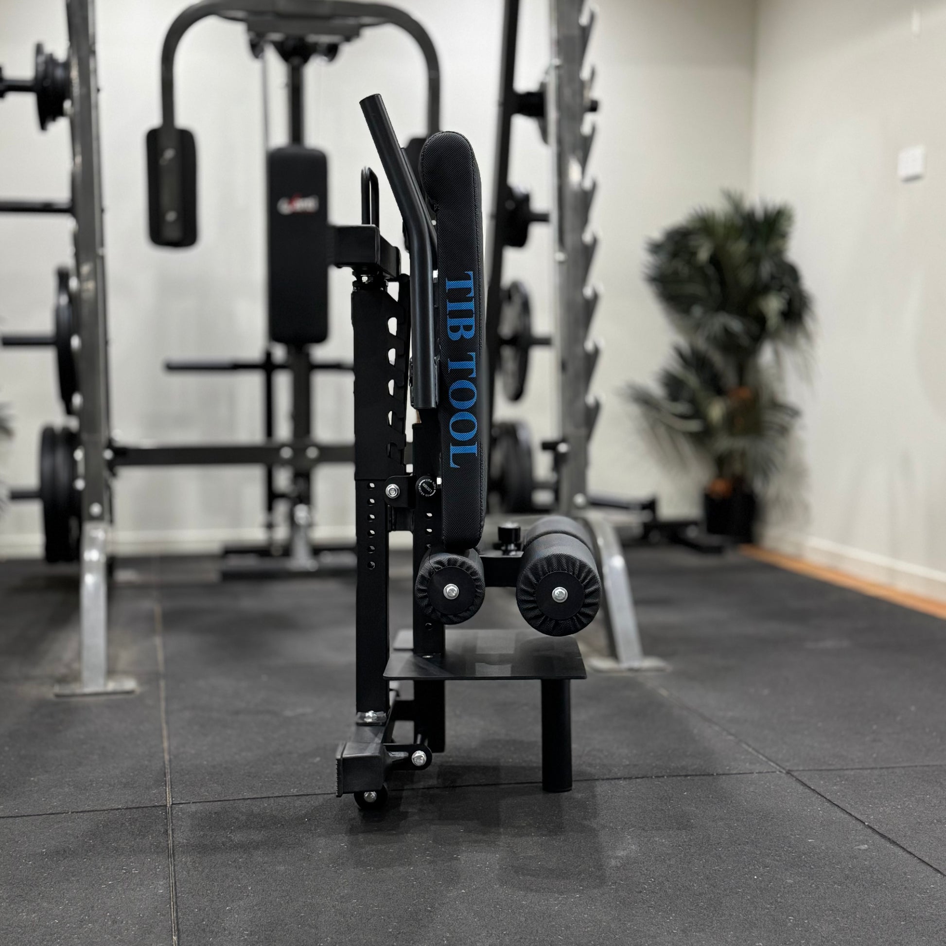 Black exercise tool with 'TIB TOOL' branding in a gym setting