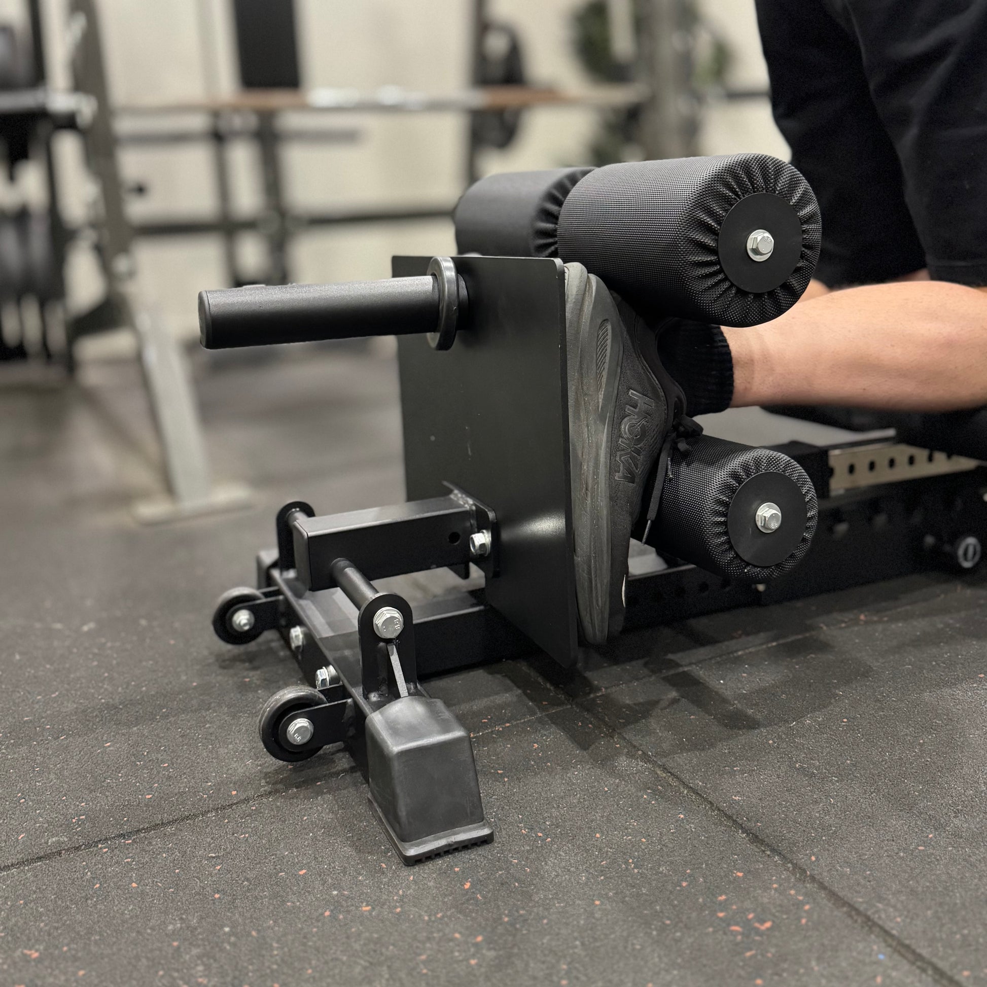 Gym equipment with a person using it in a blurred gym setting