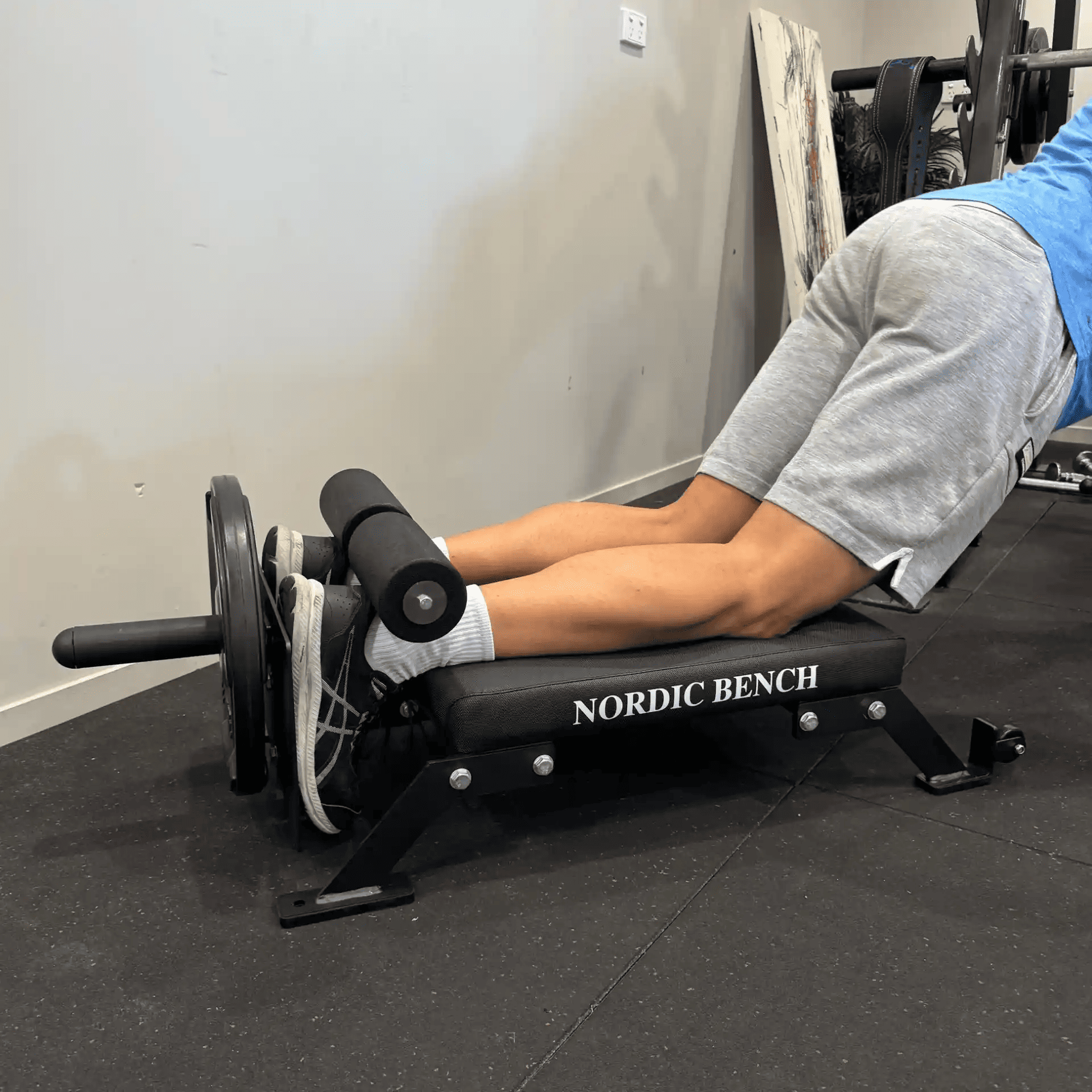 A person performing an exercise on a Nordic bench, emphasizing leg strength and stability in a fitness setting. The Nordic bench is designed for effective workouts.