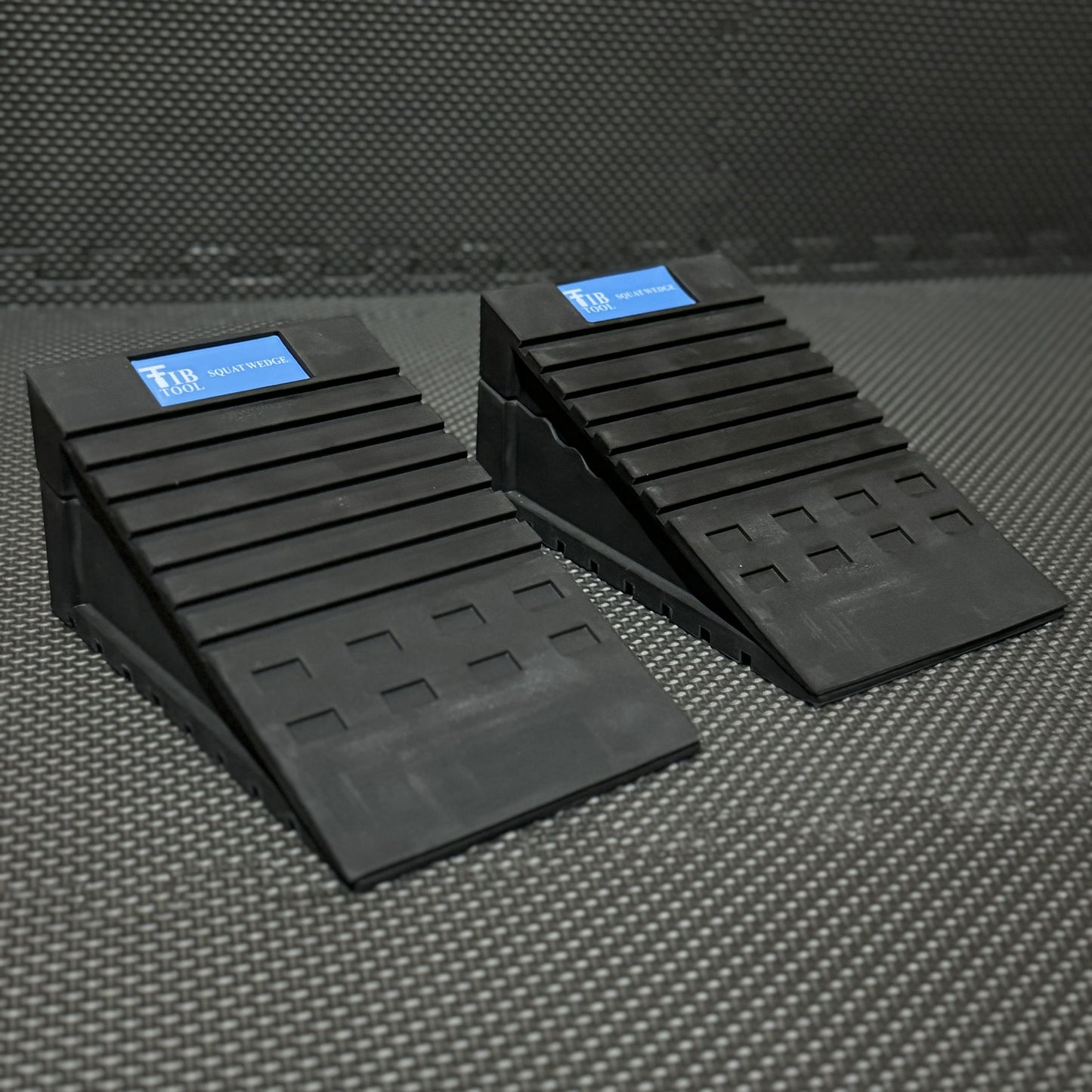 Two black rubber squat wedges designed for fitness, featuring a textured surface for stability during exercises.