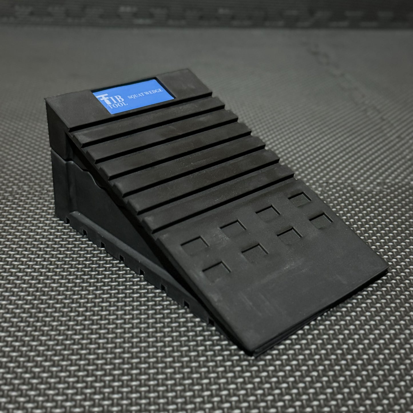 Black rubber squat wedges designed for gym use, featuring a textured surface for stability and support during exercises.