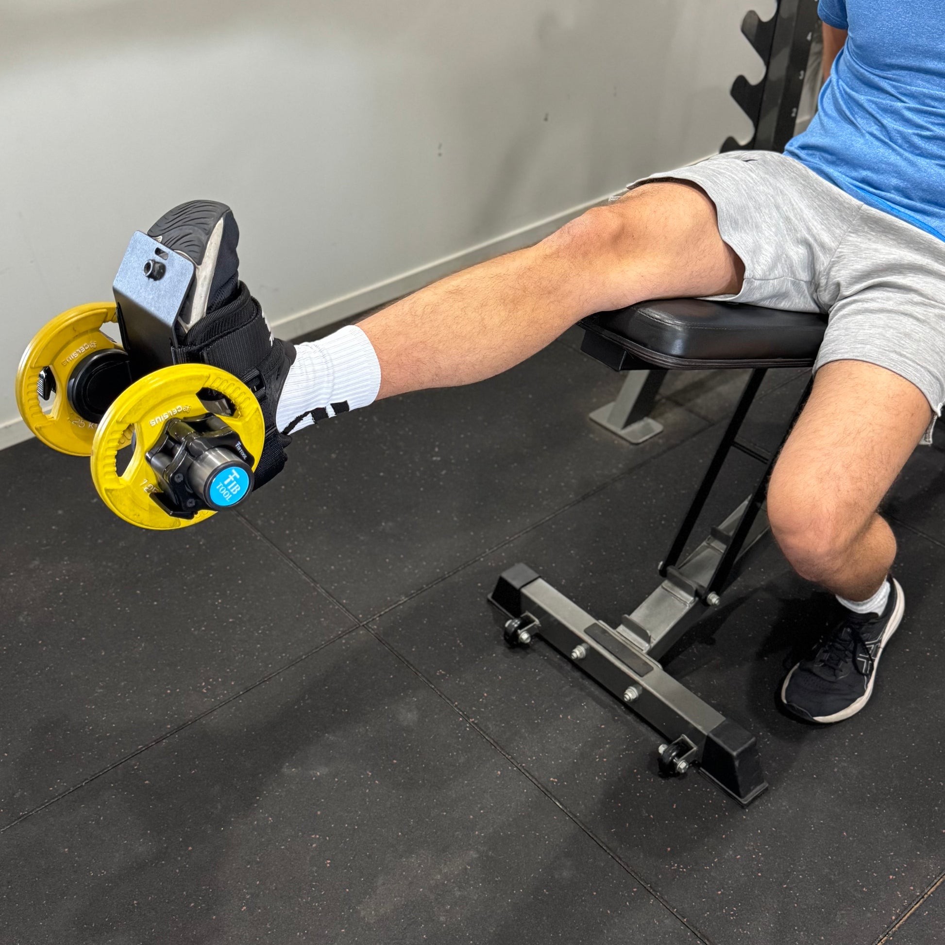 Person using a leg extension machine in a gym setting for quads.