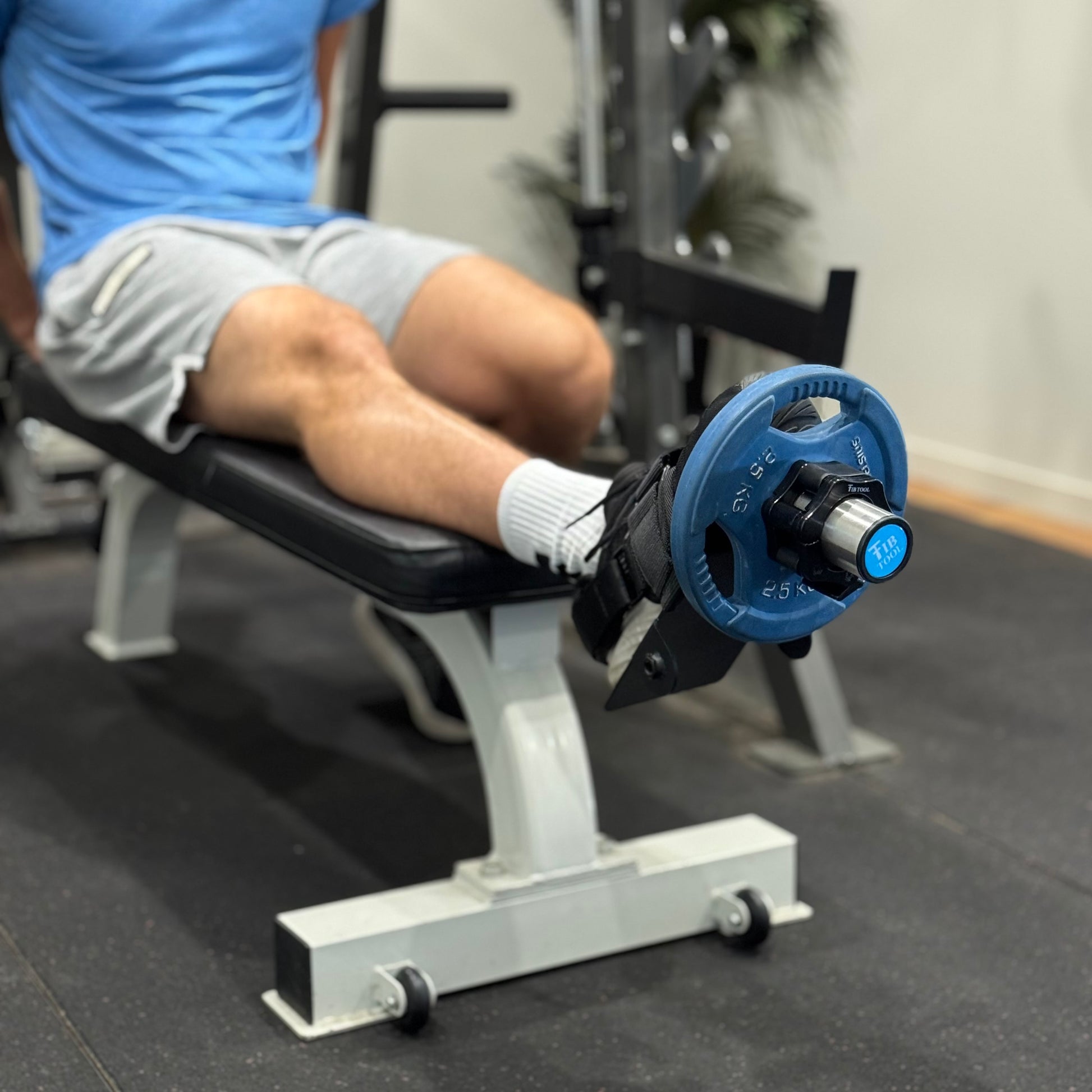 Person using single leg tib bar at end of bench for shin splints.