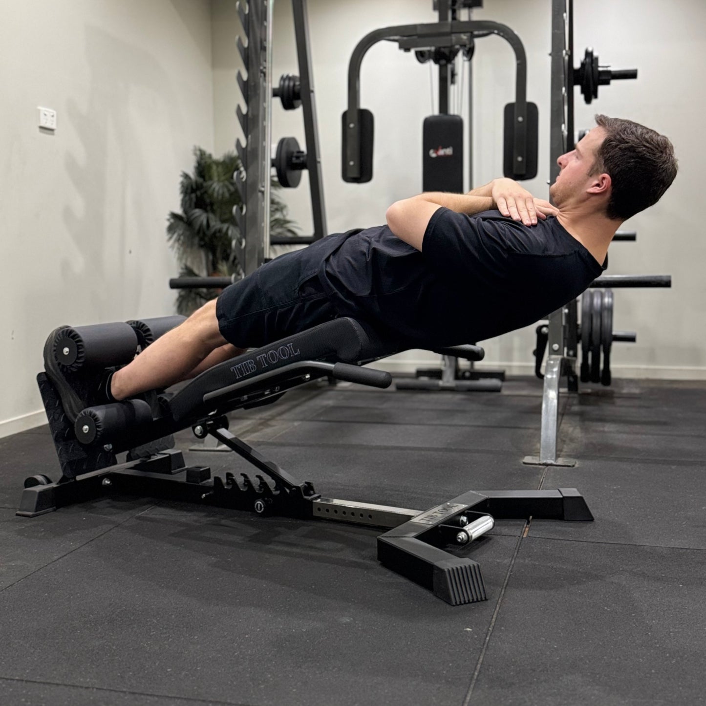 Man using a weight bench do perform sit-ups in a gym setting