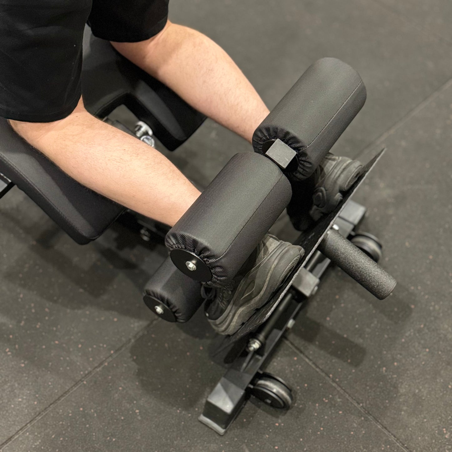 Person using a leg extension machine in a gym setting