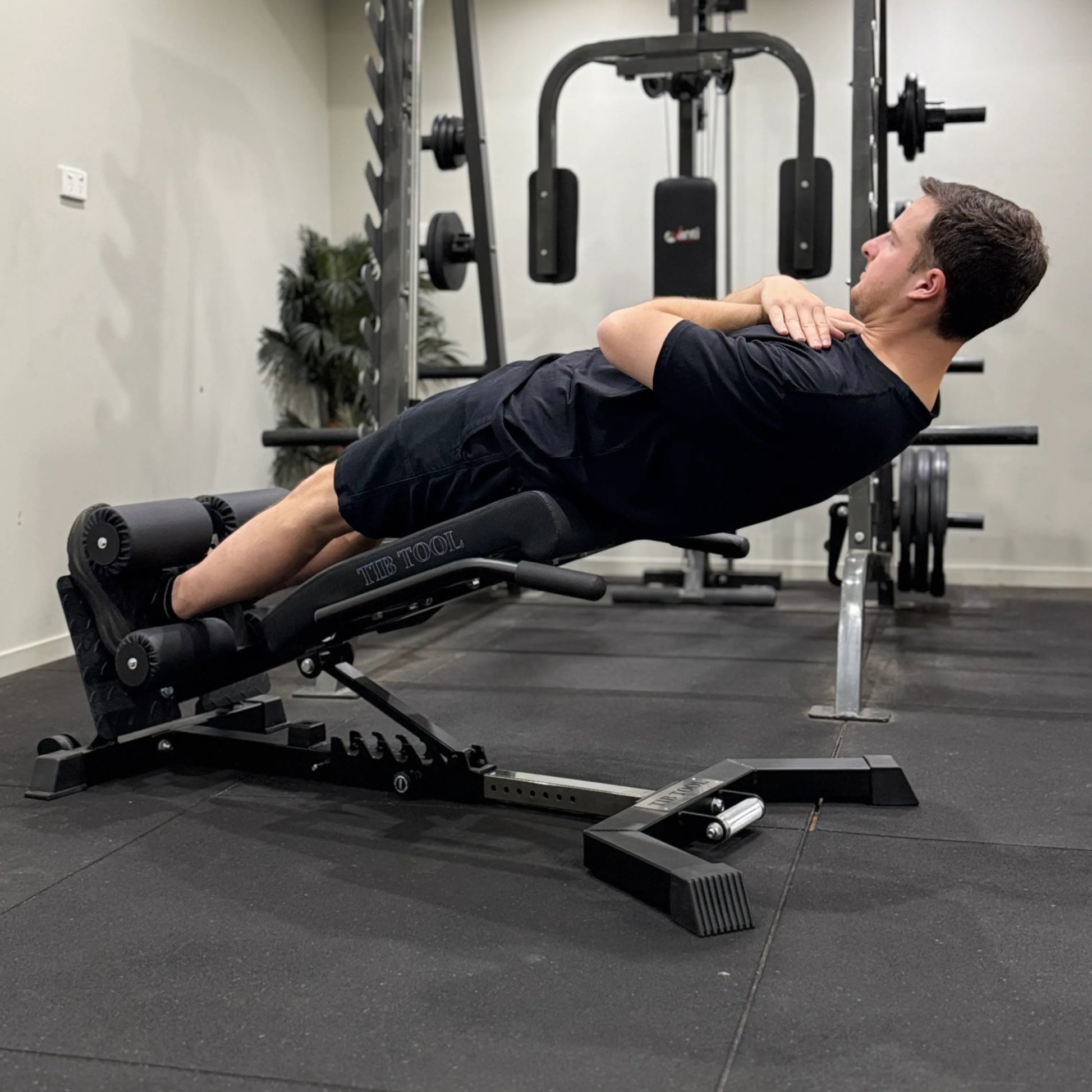 Man using a weight bench to perform decline sit-ups.