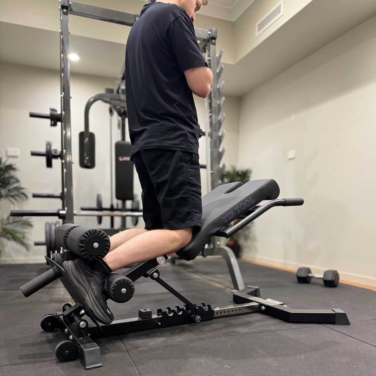 Person using a GHD weight bench in a home gym setting