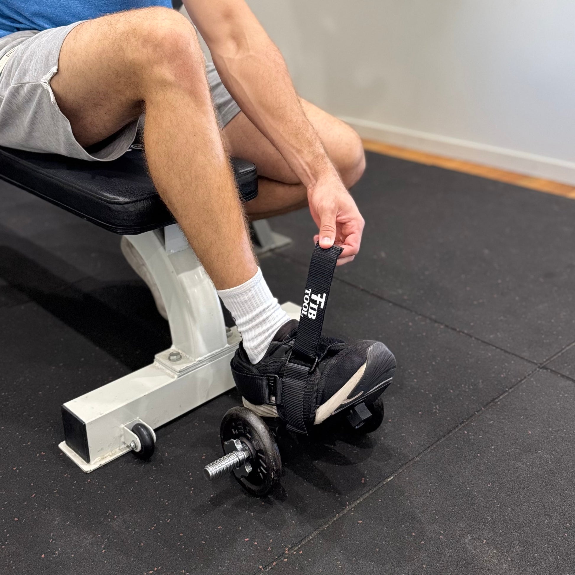 Person using a weight plate holder on a weight bench in a gym setting