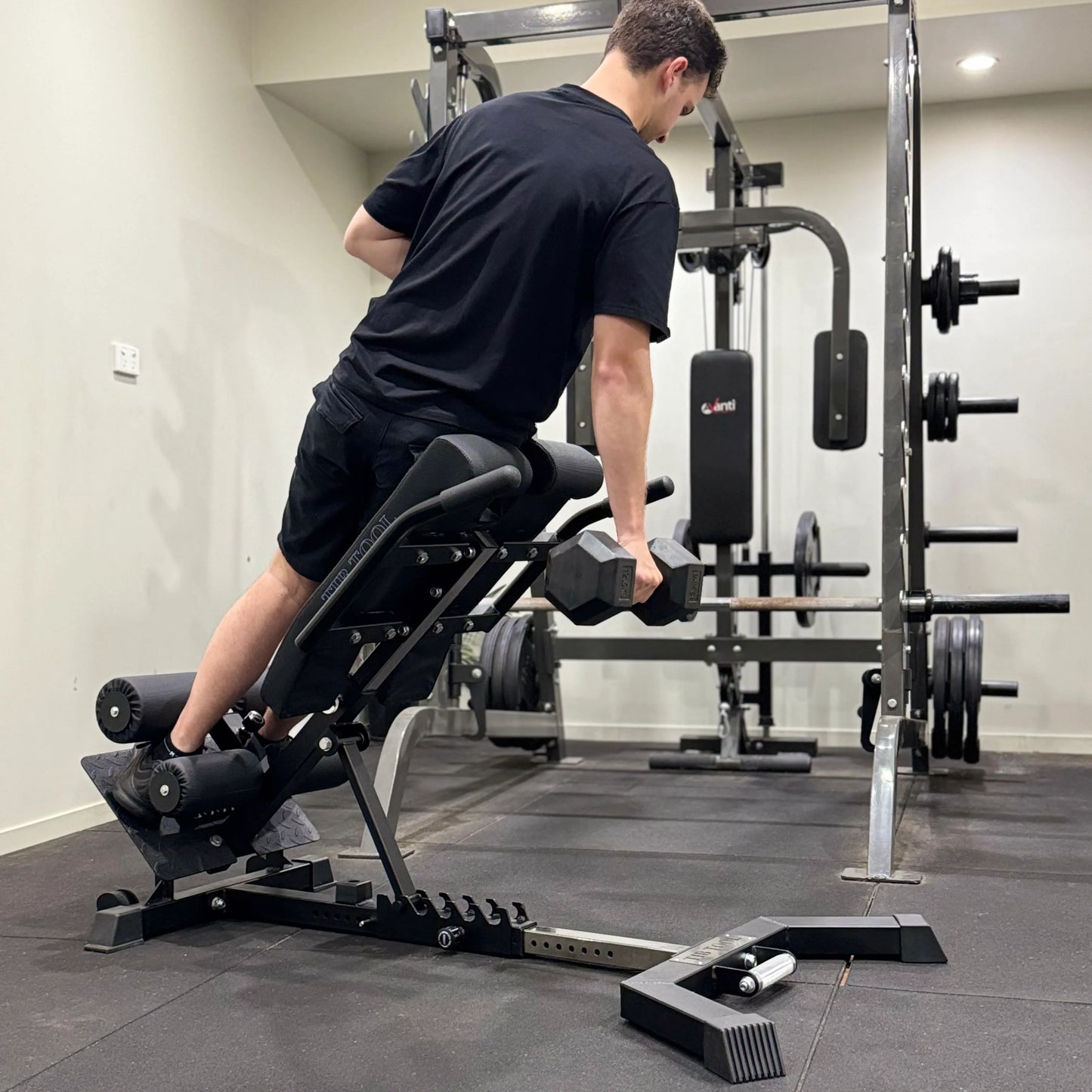 Man using a back extension machine to perform QL raises in a gym setting.